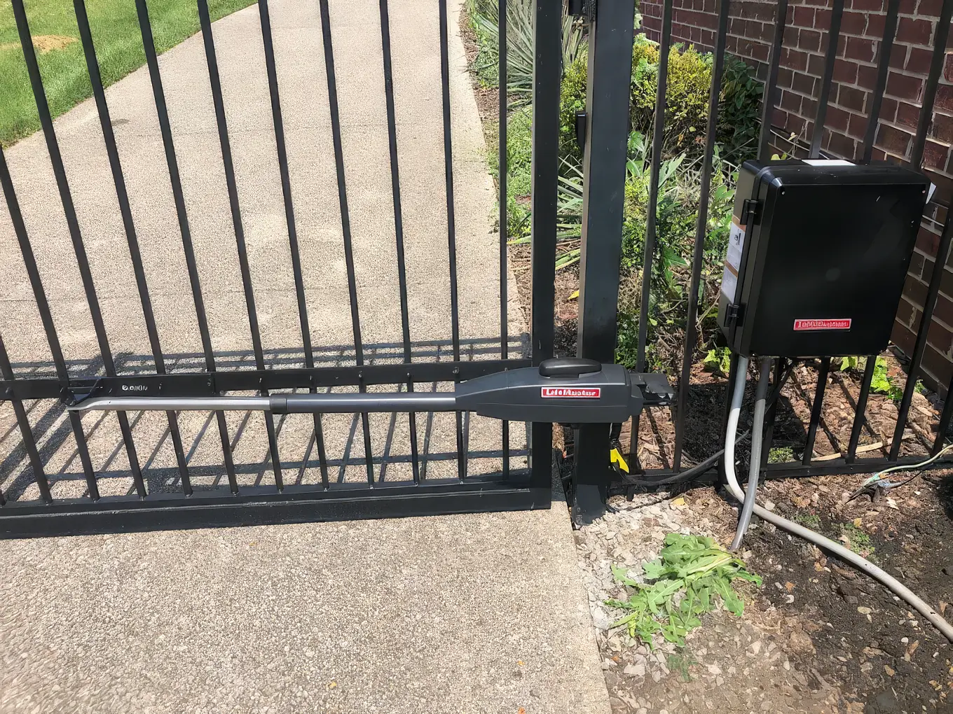 LiftMaster gate operator arm and control box installed on a residential iron gate
